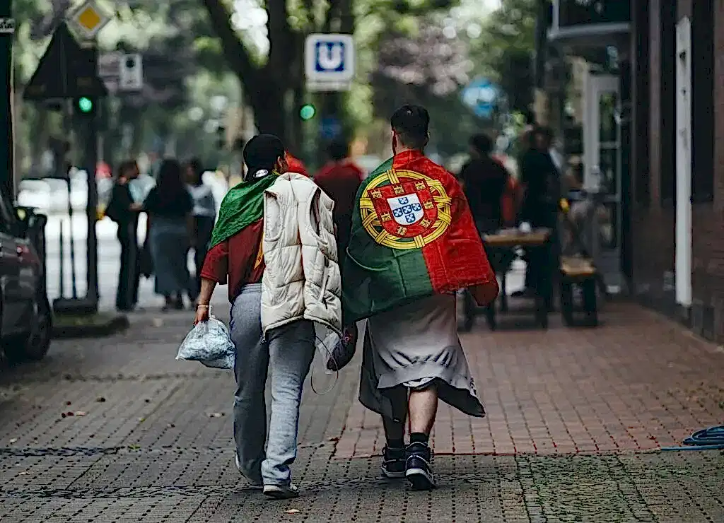 A couple of people walking down a street